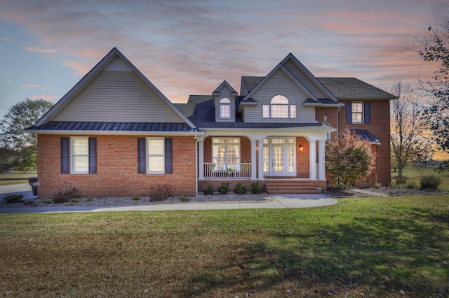 view of front facade with a lawn and covered porch