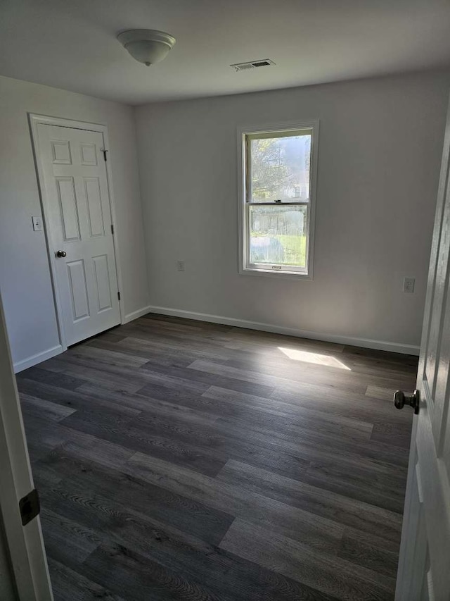 spare room featuring dark wood-type flooring