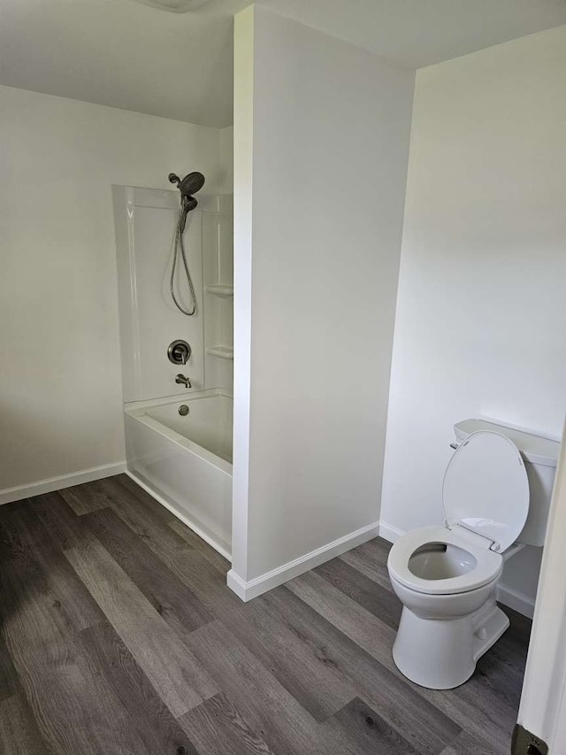 bathroom featuring toilet, wood-type flooring, and bathtub / shower combination