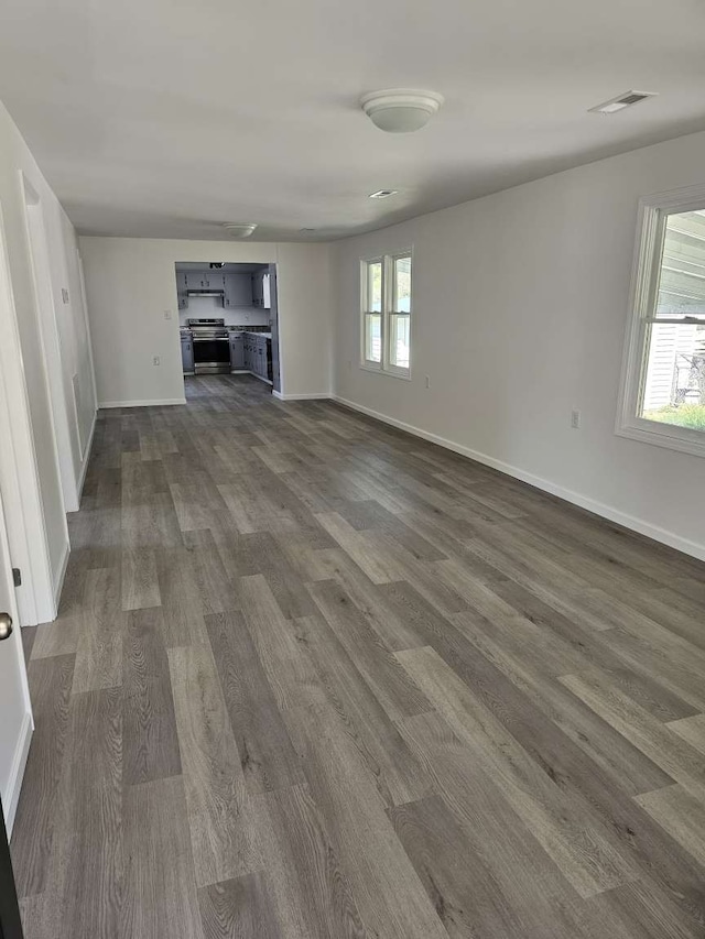 unfurnished living room featuring dark hardwood / wood-style flooring and plenty of natural light