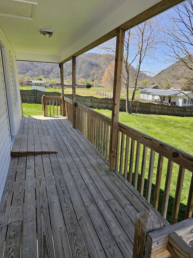 wooden deck featuring a lawn and a mountain view