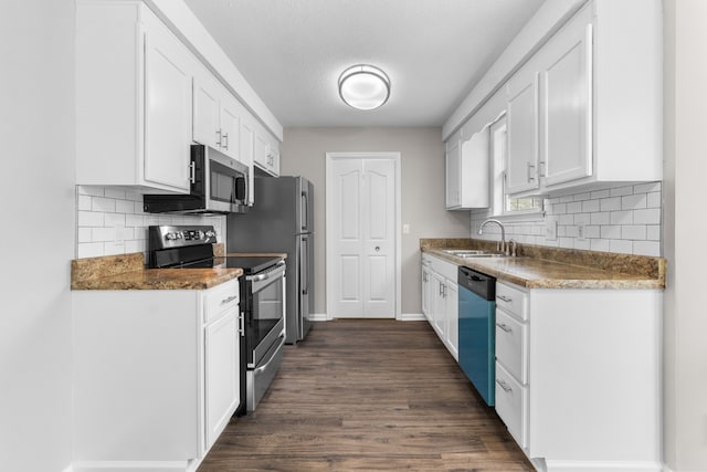 kitchen with white cabinets, sink, a textured ceiling, appliances with stainless steel finishes, and dark hardwood / wood-style flooring