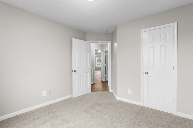 unfurnished bedroom featuring carpet flooring and a textured ceiling