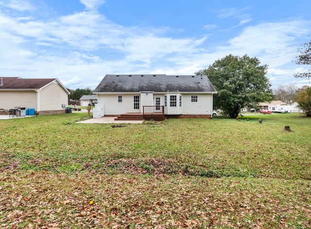 back of property with a yard, a patio, and a wooden deck