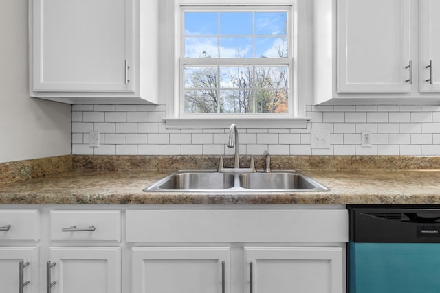 kitchen featuring tasteful backsplash, dishwasher, white cabinets, and sink