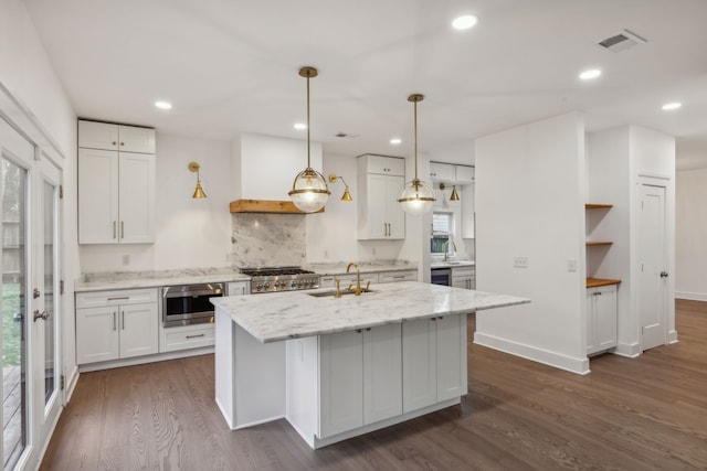 kitchen with white cabinets, a center island with sink, sink, dark hardwood / wood-style floors, and stainless steel appliances