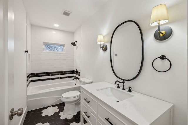 full bathroom with tile patterned flooring, vanity, tiled shower / bath combo, and toilet