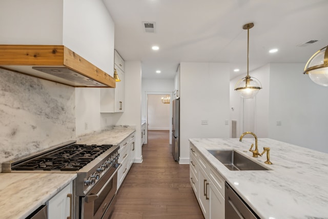 kitchen featuring ventilation hood, sink, hanging light fixtures, white cabinetry, and stainless steel appliances