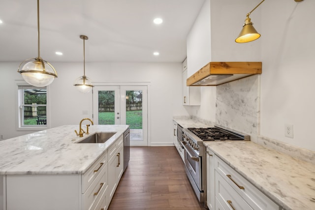 kitchen featuring white cabinets, appliances with stainless steel finishes, an island with sink, and sink