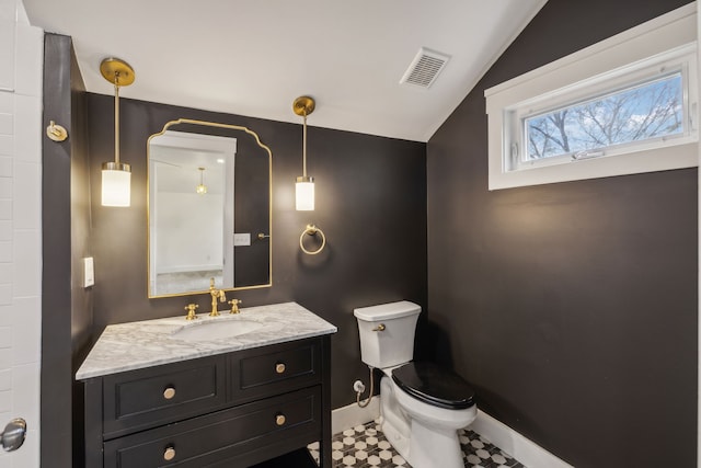 bathroom featuring toilet, vanity, tile patterned floors, and lofted ceiling