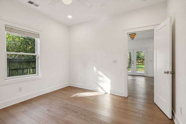 empty room with hardwood / wood-style floors, ceiling fan, and french doors