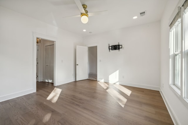 unfurnished bedroom featuring a closet, ceiling fan, and dark wood-type flooring