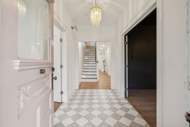 hall featuring light wood-type flooring and an inviting chandelier