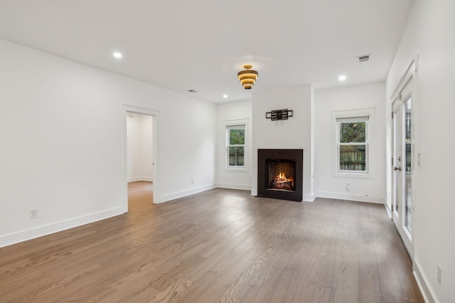 unfurnished living room with wood-type flooring and a wealth of natural light