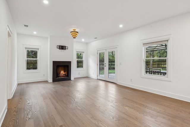 unfurnished living room with french doors and light wood-type flooring