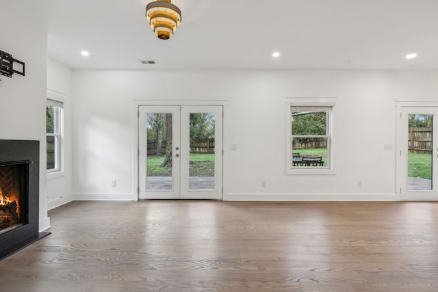 unfurnished living room featuring hardwood / wood-style flooring and french doors