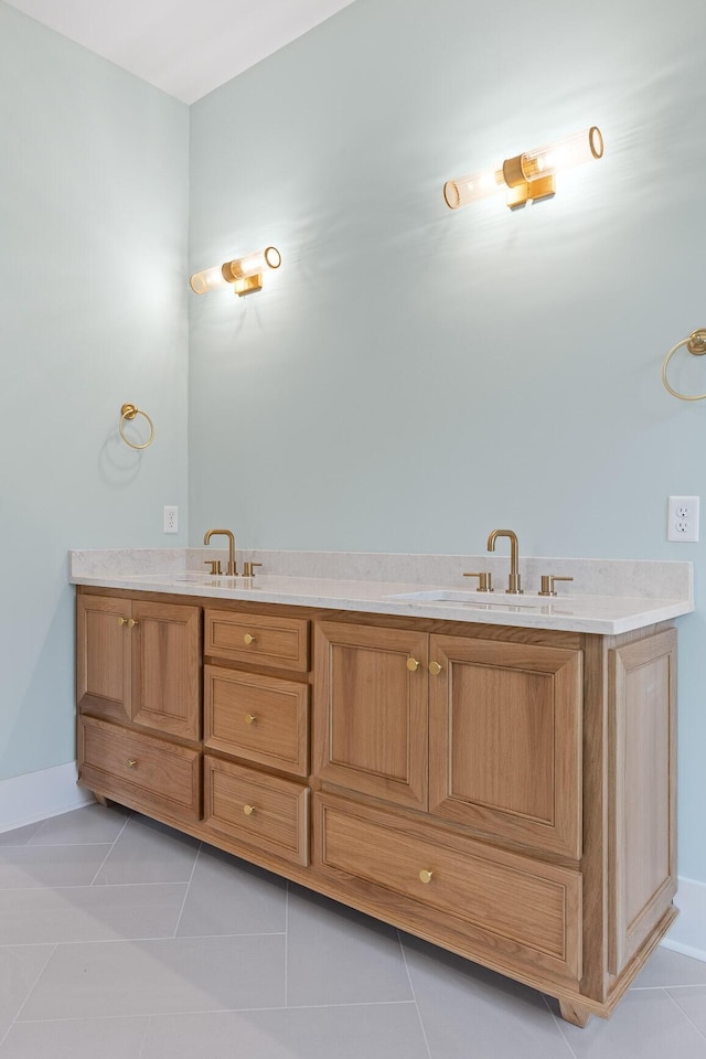 bathroom featuring a sink, tile patterned floors, and baseboards
