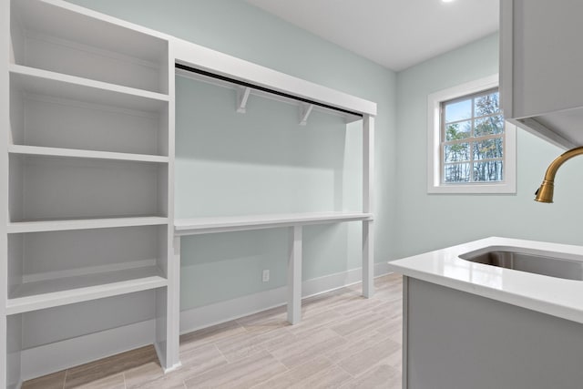 spacious closet with a sink and light wood finished floors