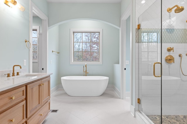 full bathroom featuring a stall shower, plenty of natural light, a soaking tub, and vanity
