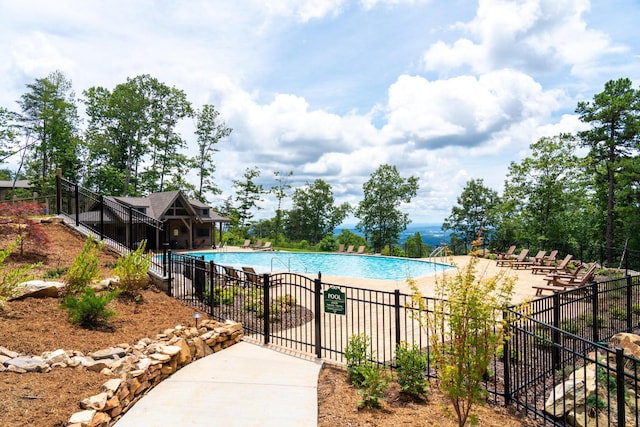 community pool with fence and a patio area