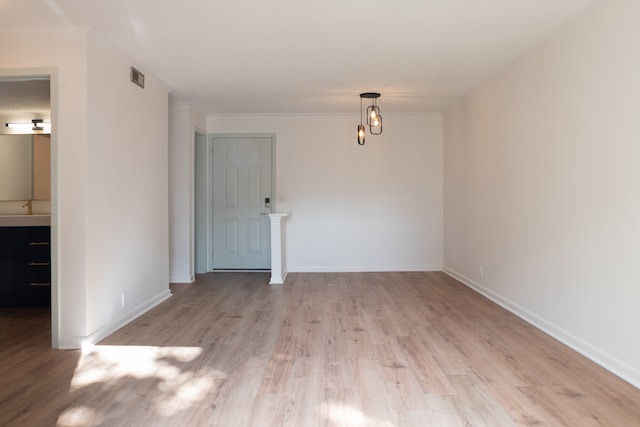 unfurnished room featuring crown molding and light hardwood / wood-style floors