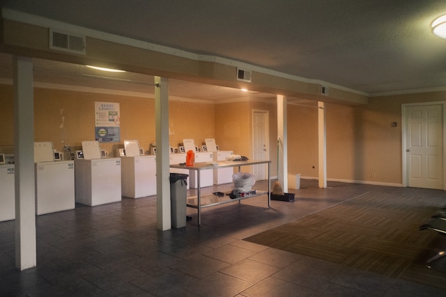 basement featuring ornamental molding and washing machine and clothes dryer