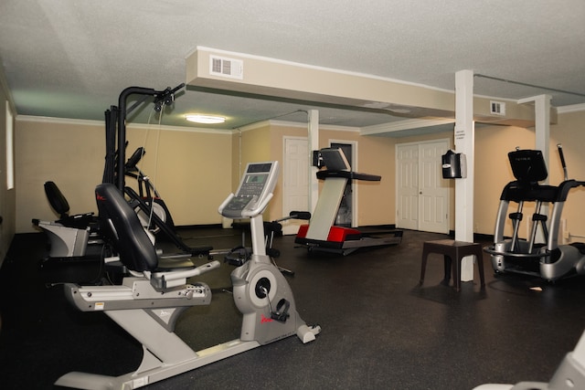 gym with ornamental molding and a textured ceiling