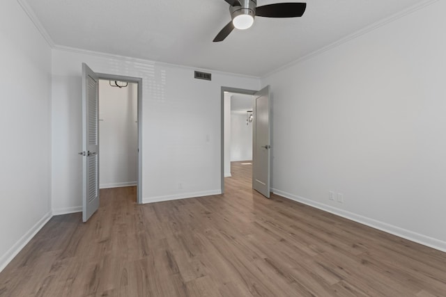 unfurnished bedroom with ornamental molding, light wood-type flooring, and ceiling fan