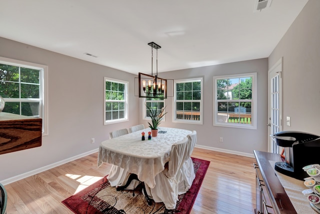 dining space featuring light hardwood / wood-style floors and an inviting chandelier