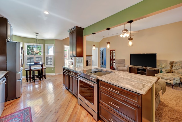 kitchen with appliances with stainless steel finishes, lofted ceiling, light hardwood / wood-style flooring, and pendant lighting