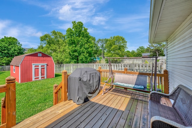 wooden terrace with a yard, a storage unit, and grilling area