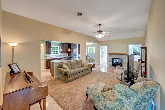 living room featuring ceiling fan, light tile patterned flooring, and a healthy amount of sunlight