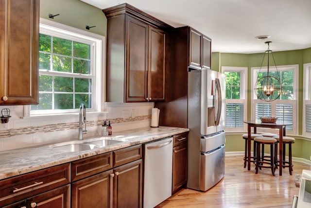 kitchen with appliances with stainless steel finishes, a healthy amount of sunlight, and sink