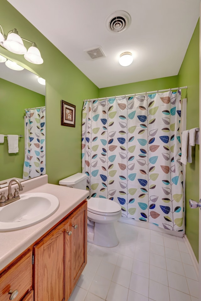 bathroom featuring walk in shower, tile patterned flooring, vanity, and toilet