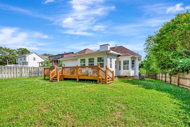 rear view of house with a lawn, central AC unit, and a deck