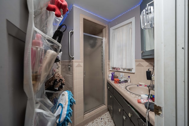 bathroom with vanity, tasteful backsplash, tile patterned floors, and a shower with door