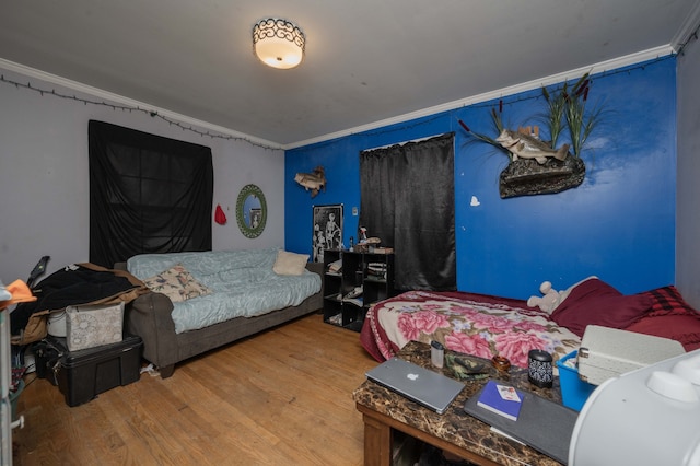 bedroom with wood-type flooring and ornamental molding