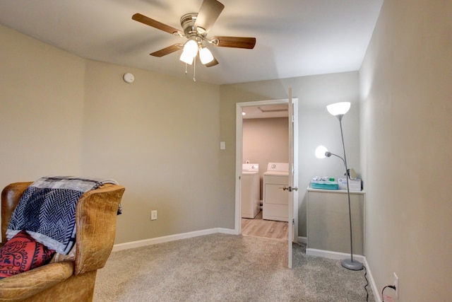 sitting room featuring ceiling fan, light colored carpet, and washer and clothes dryer