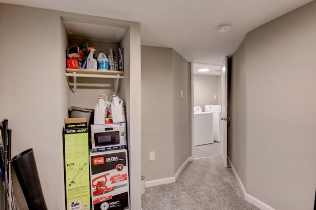 hallway with washer and dryer and light carpet