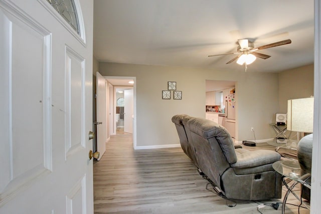 living room featuring ceiling fan and light hardwood / wood-style flooring