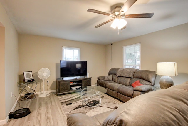 living room with light wood-type flooring, ceiling fan, and plenty of natural light