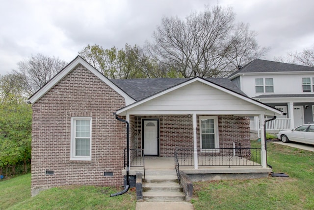 view of front of home with covered porch and a front lawn