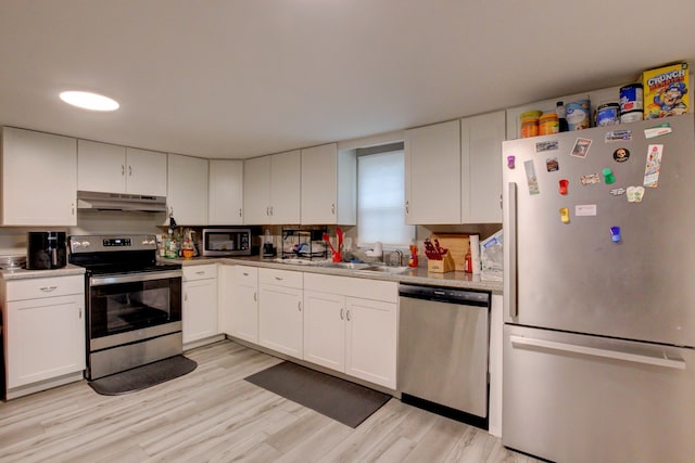 kitchen featuring sink, white cabinetry, appliances with stainless steel finishes, and light wood-type flooring