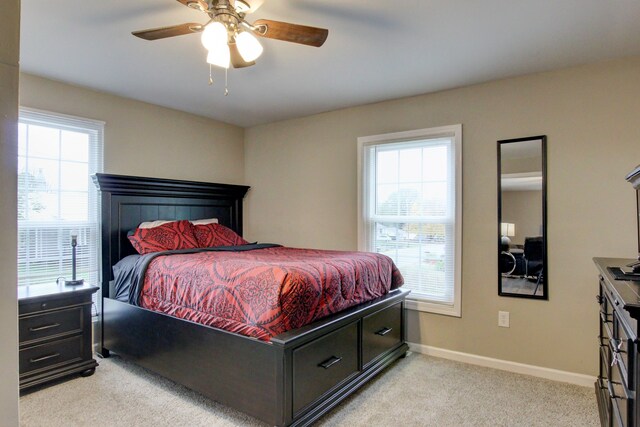 carpeted bedroom with multiple windows and ceiling fan