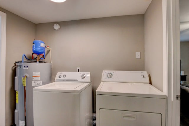 clothes washing area featuring separate washer and dryer and electric water heater