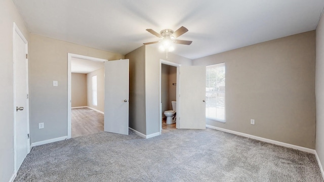 unfurnished bedroom with ceiling fan, connected bathroom, and light carpet