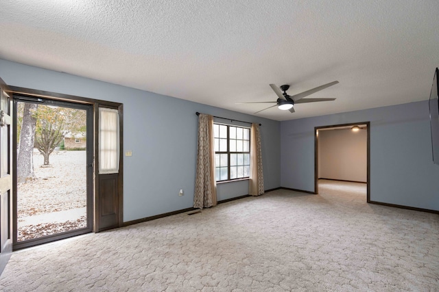 unfurnished room with light carpet, ceiling fan, and a textured ceiling