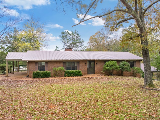 ranch-style home featuring a front lawn and a carport