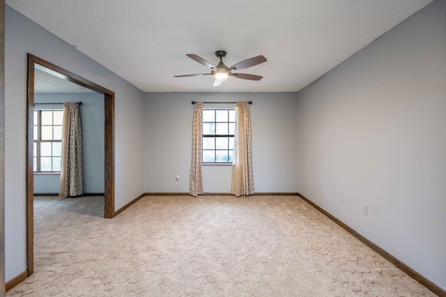 carpeted spare room with ceiling fan