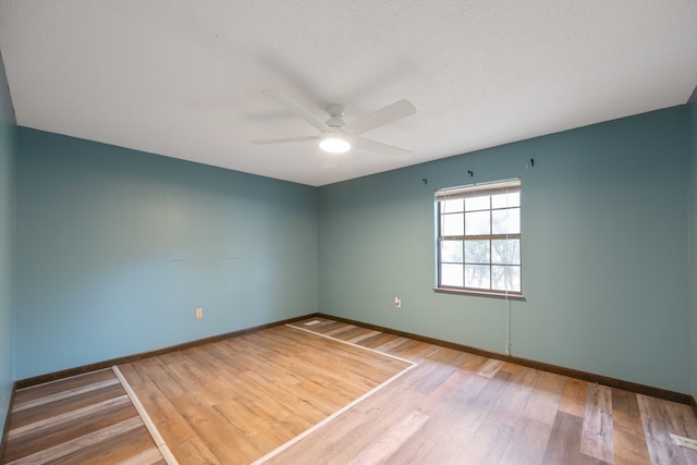 empty room with hardwood / wood-style floors, ceiling fan, and a textured ceiling